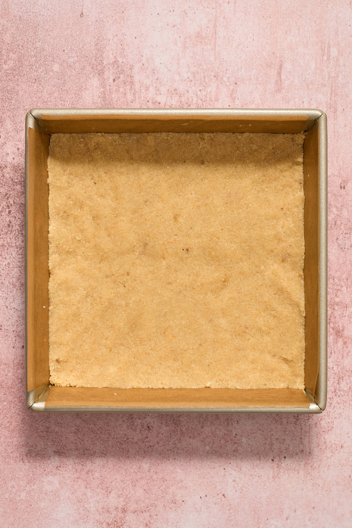 Crust mixture pressed into the bottom of a square pan.