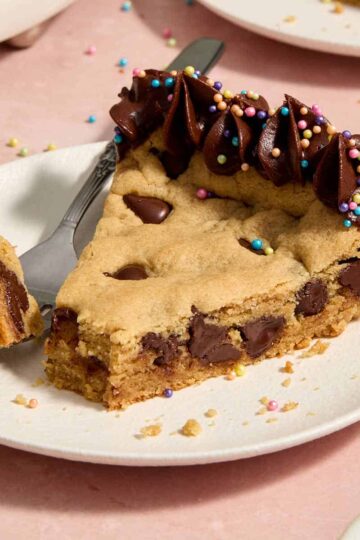 Slice of almond flour peanut butter chocolate chip cookie cake served on a plate with a forkful removed.