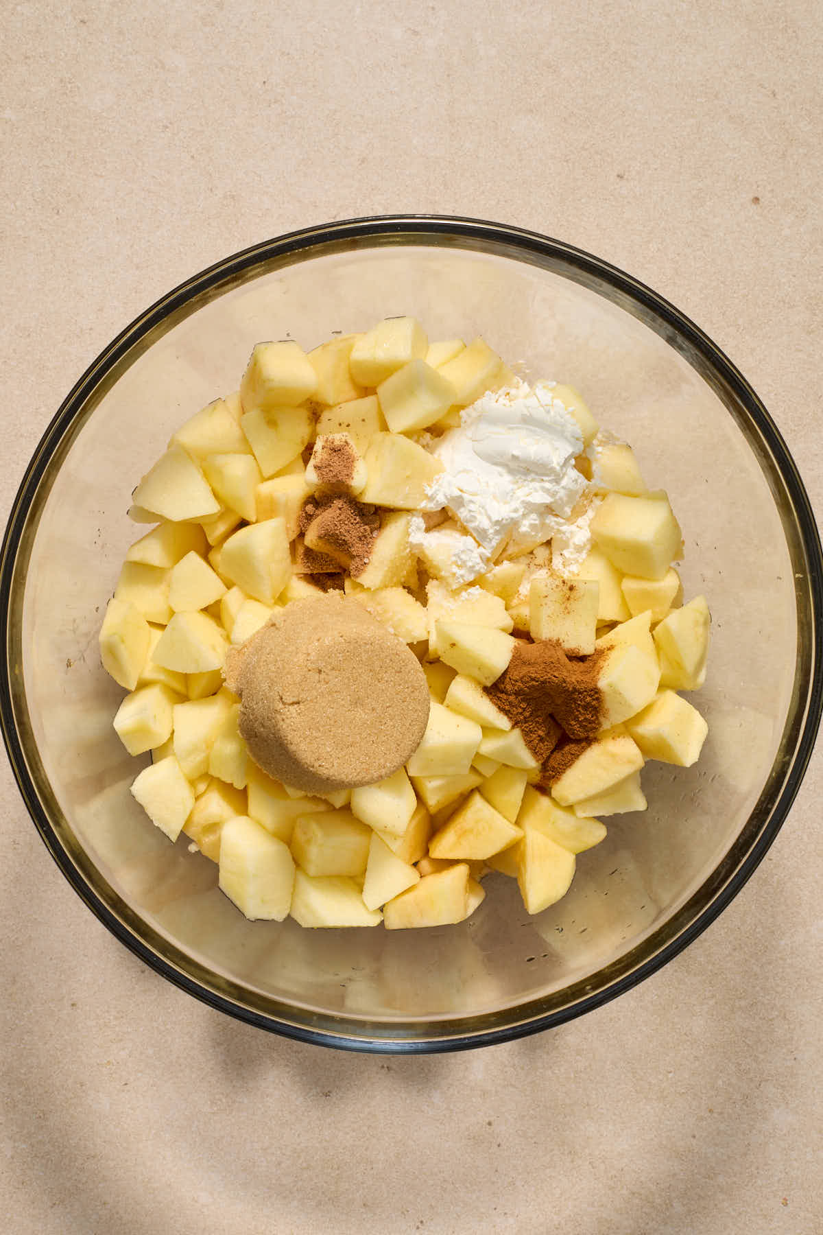 Chopped apples and other filling ingredients in a large glass bowl.