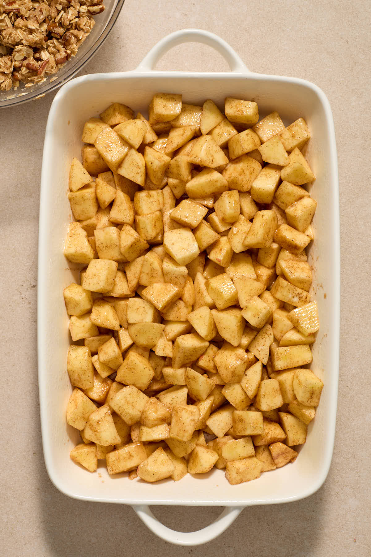 Apple filling spread out in white baking dish.