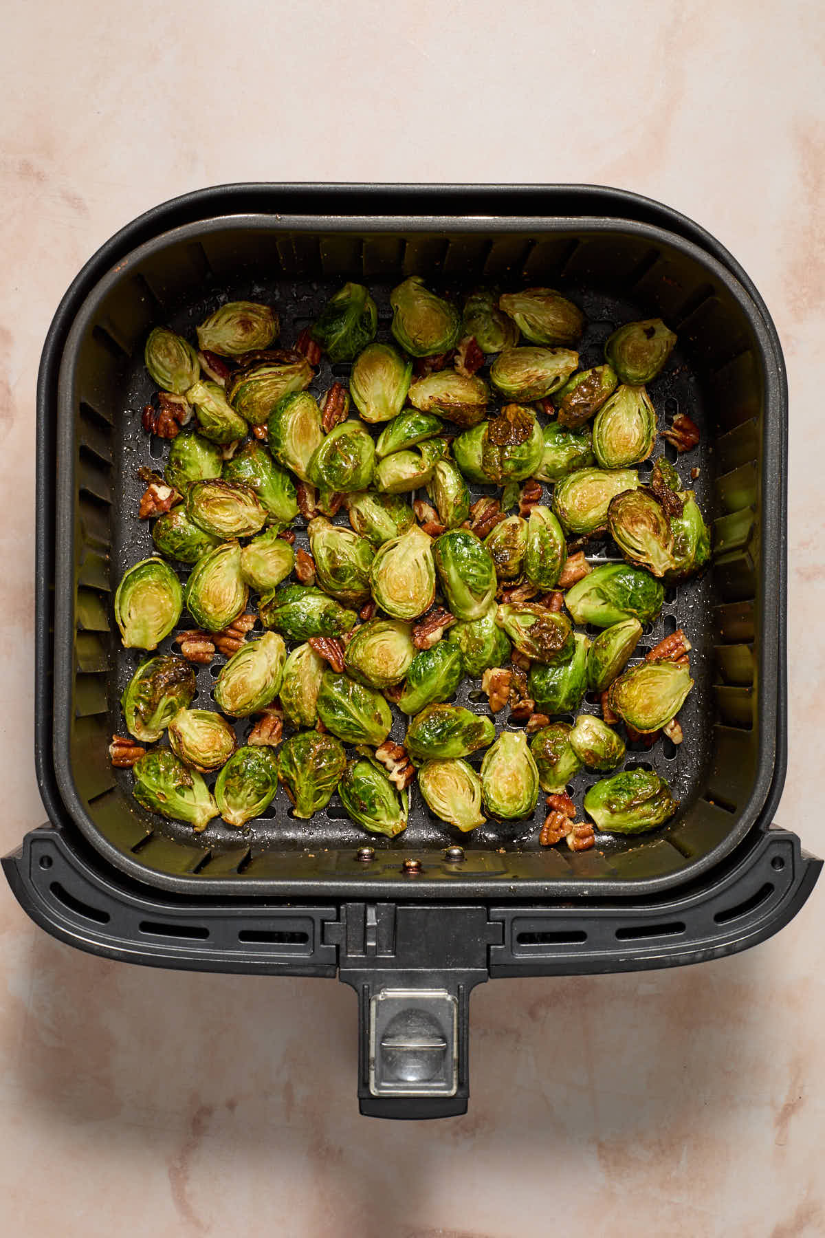 Maple pecan Brussels sprouts in an air fryer basket.