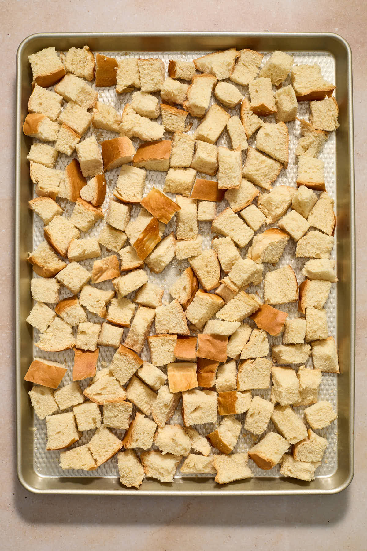 Cubed bread dried out on a sheet pan.