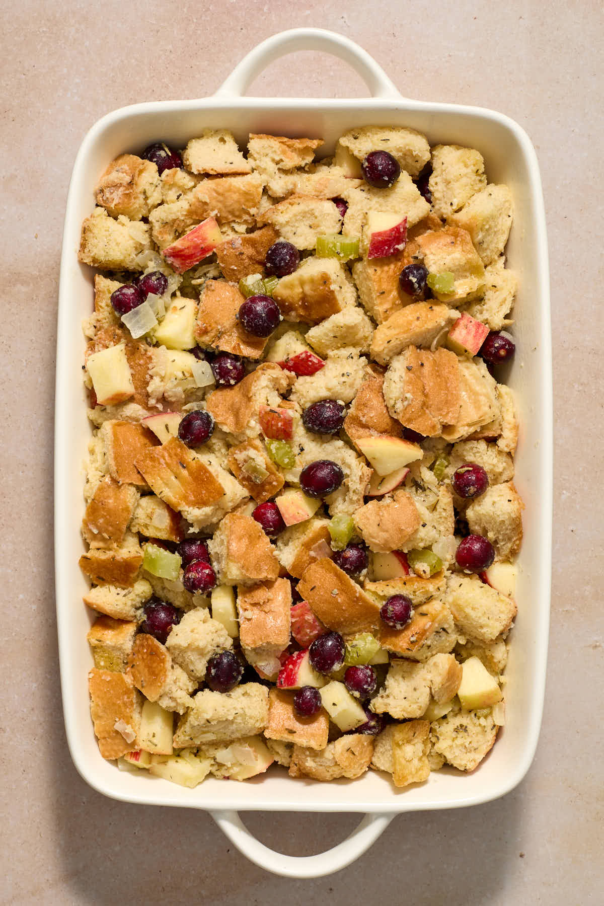 Stuffing mixture spread out in a white baking dish.