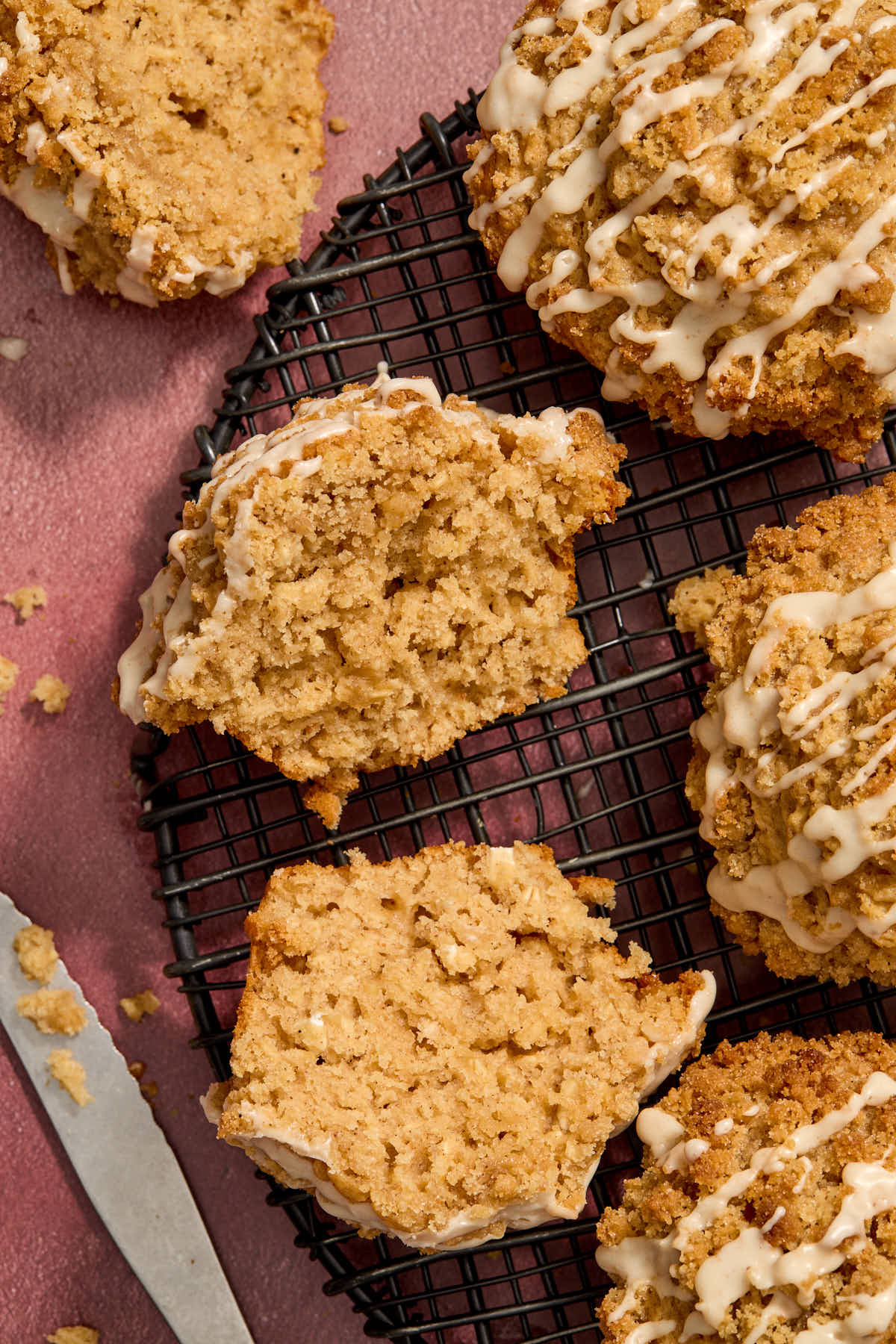 Overhead shot of eggnog muffins on a wire rack with one cut in half.