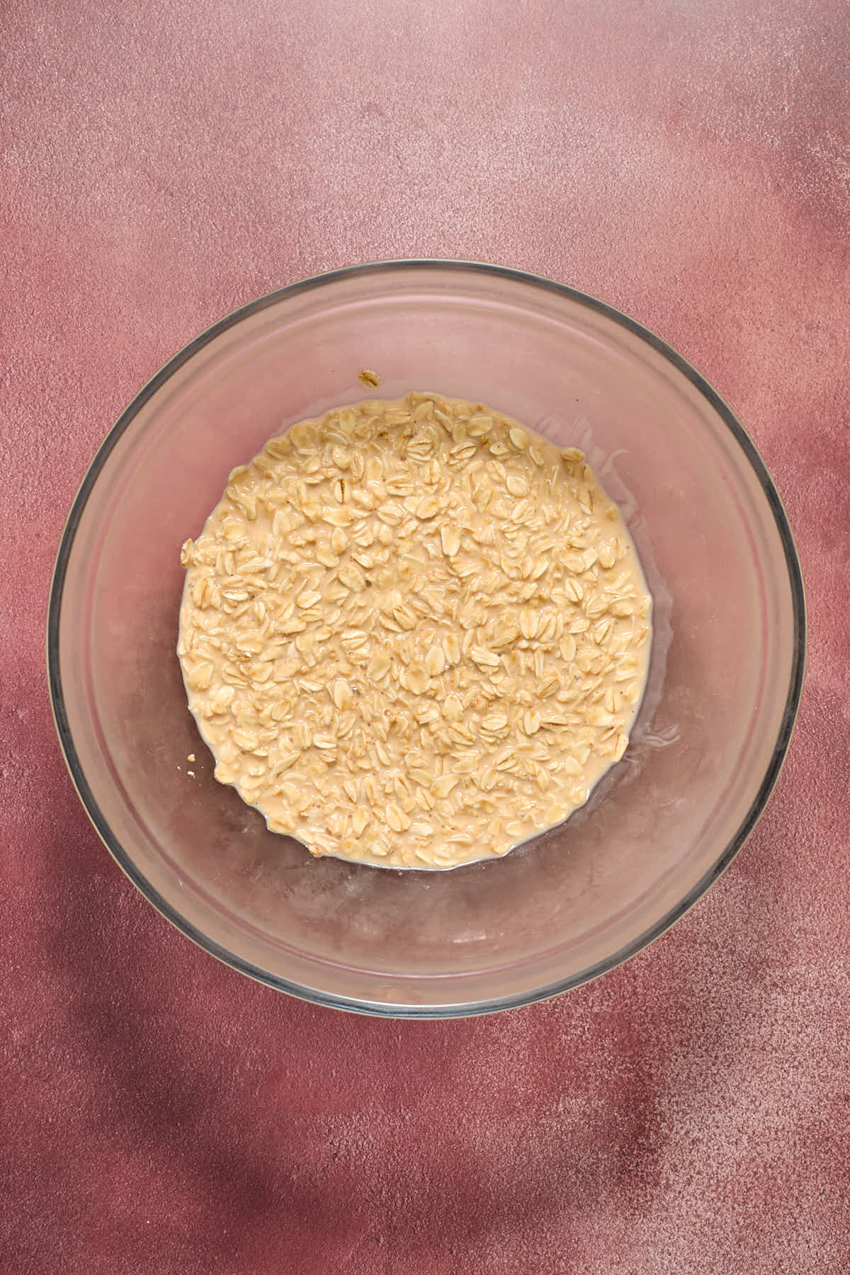 Oats soaked in eggnog in a glass bowl.