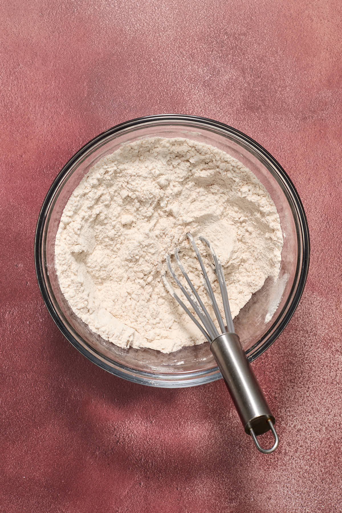 Dry ingredients whisked together in a glass bowl.