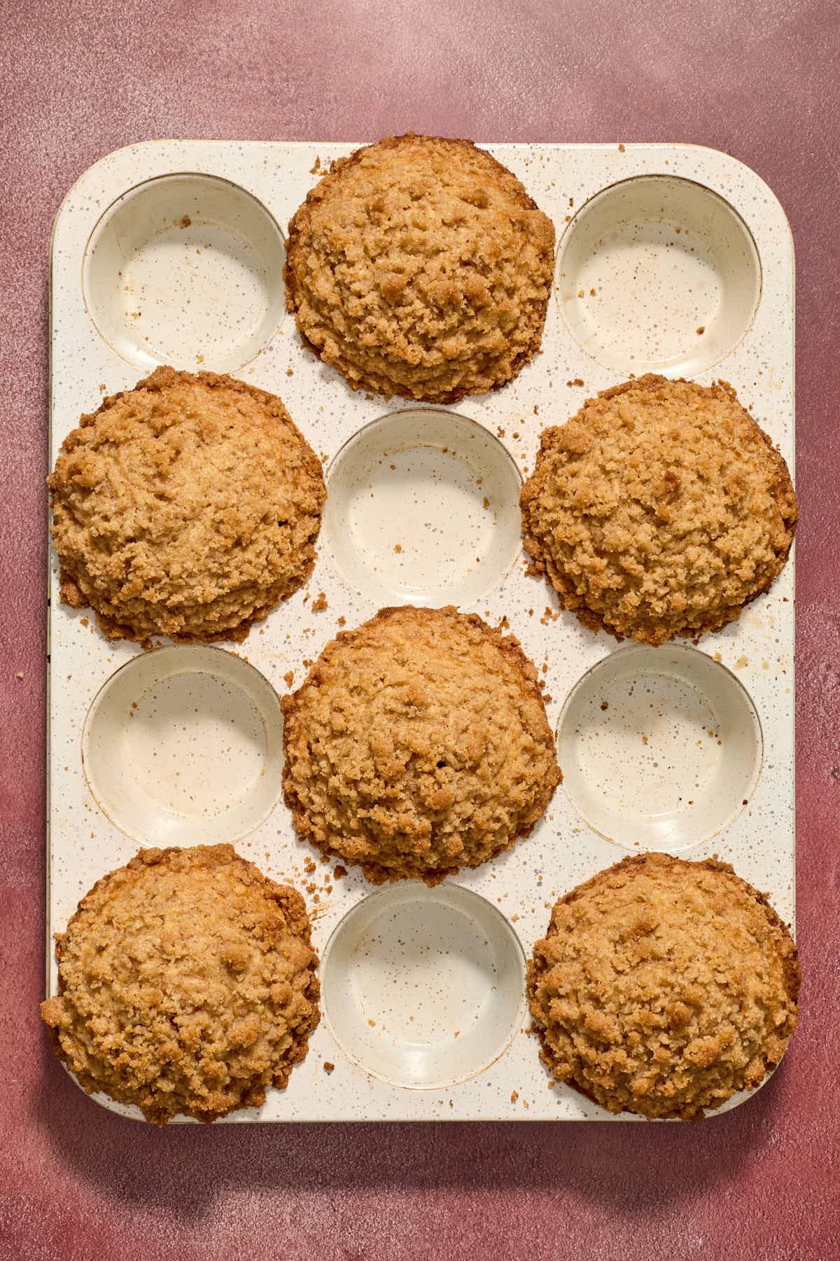 Baked muffins in a white muffin tin.