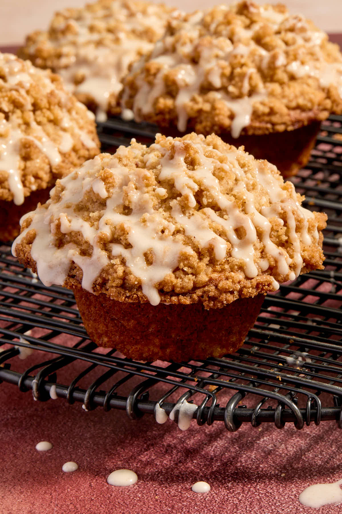 Close up side view of an eggnog muffin with streusel and eggnog glaze on top.