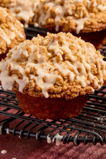 Side view of eggnog muffins with eggnog glaze drizzled on top.