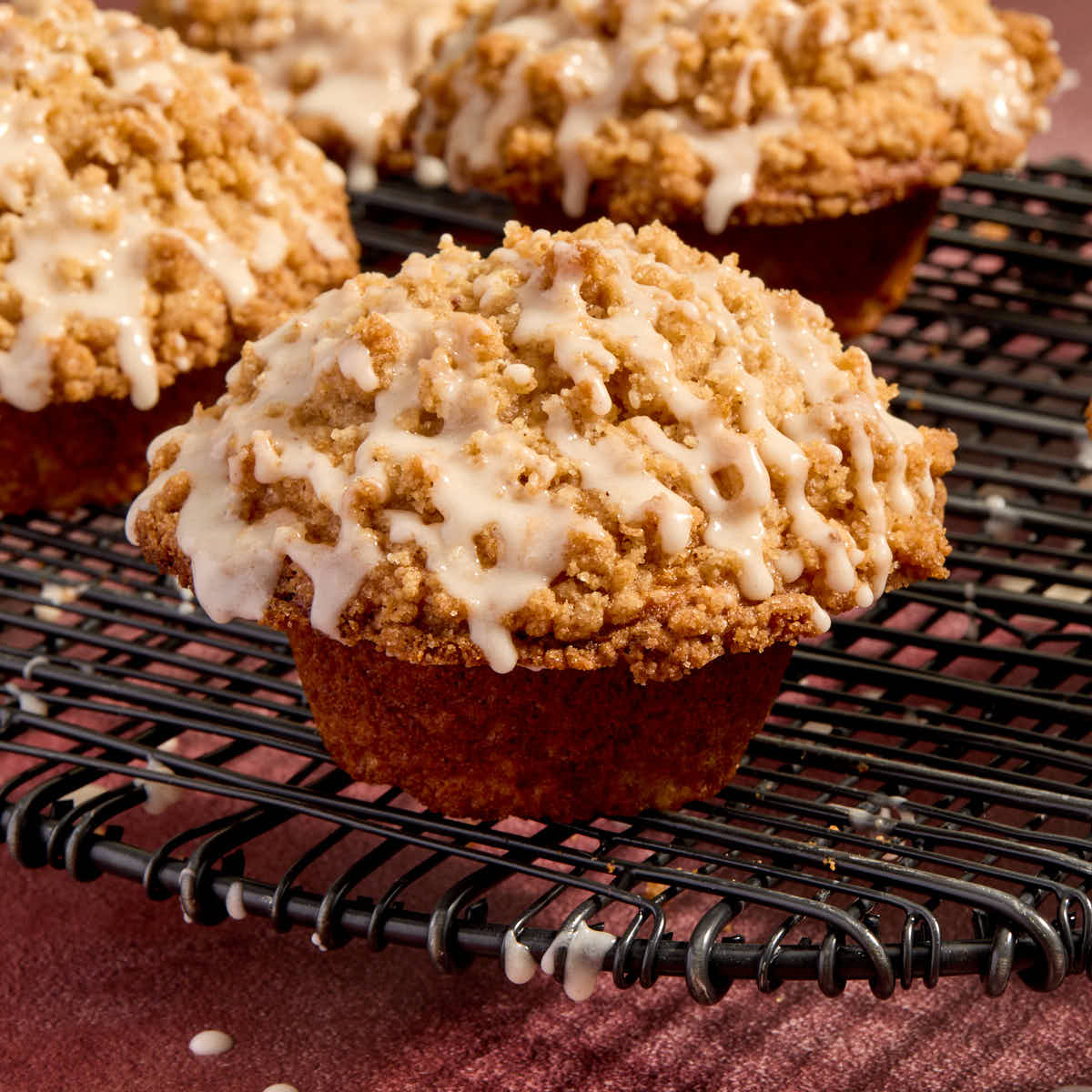 Side view of eggnog muffins with eggnog glaze drizzled on top.