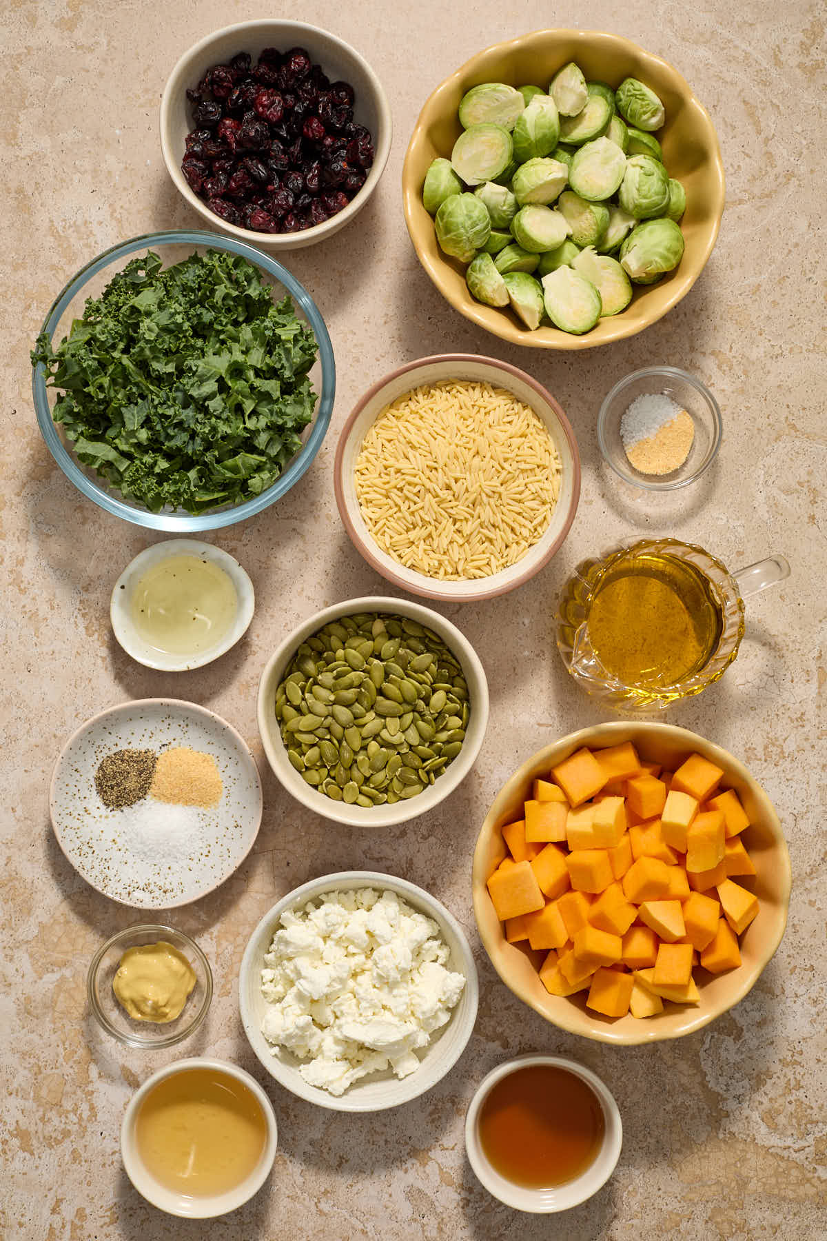 Ingredients to make a fall orzo salad arranged in individual bowls.