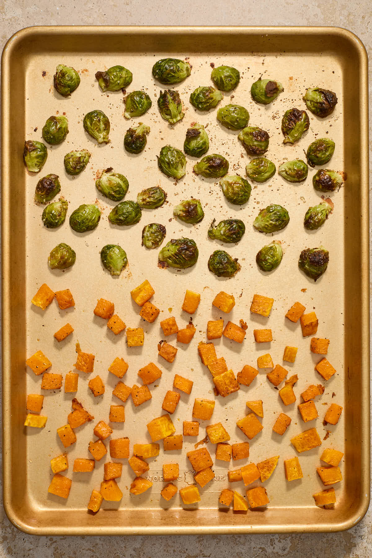 Roasted squash and Brussels sprouts on a sheet pan.