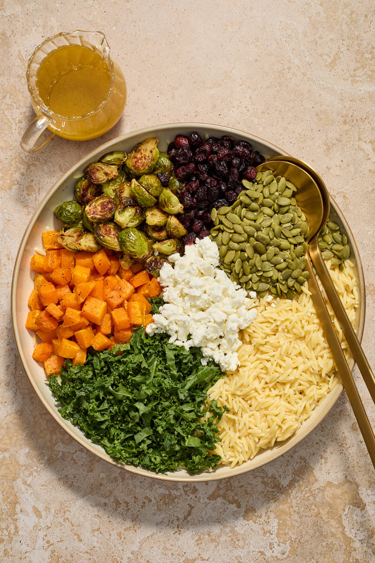 All of the salad ingredients added in sections to a large shallow bowl with the vinaigrette on the side.