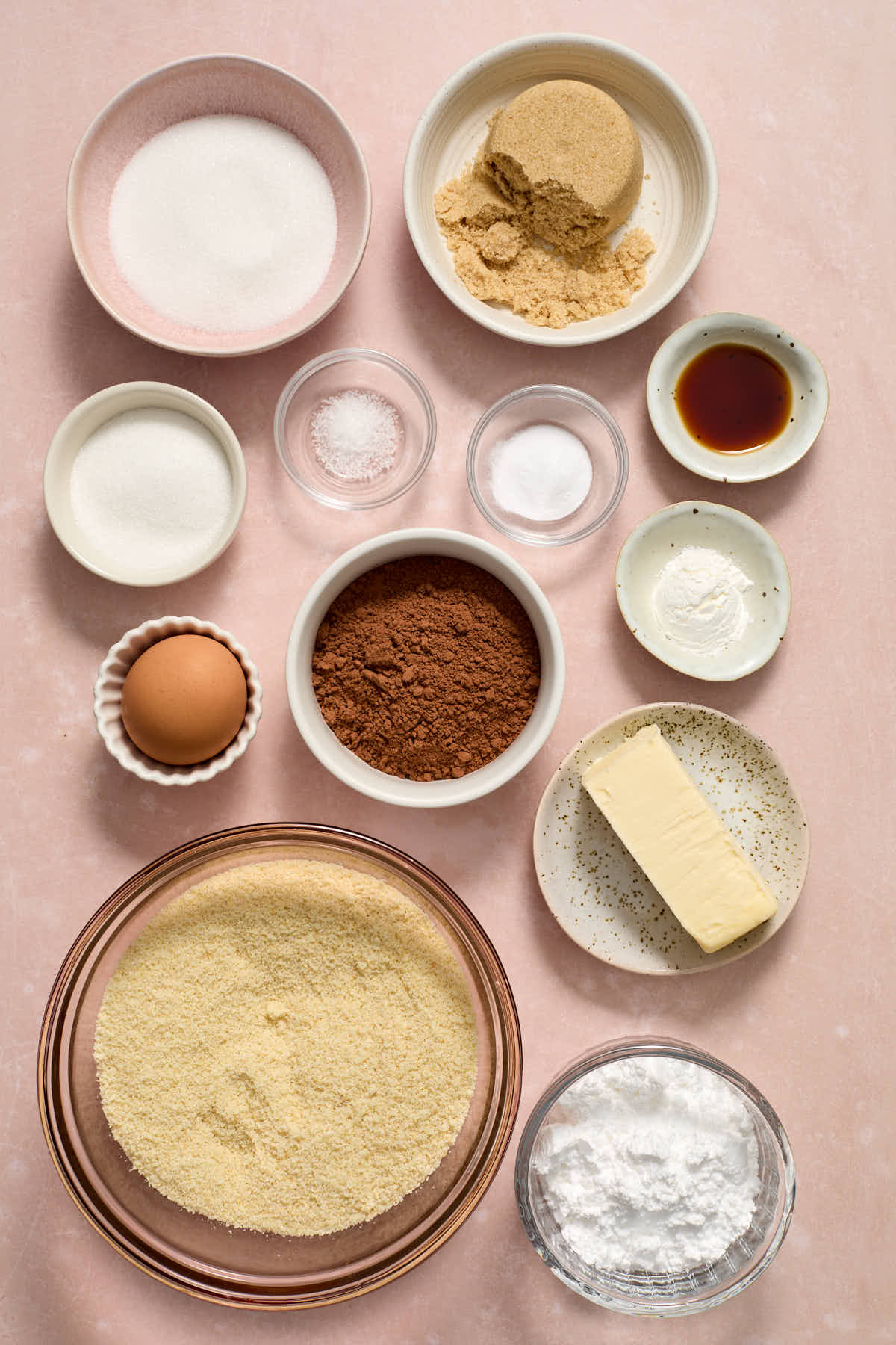 Ingredients to make chocolate crinkle cookies arranged in individual bowls.