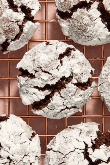Almond Flour Chocolate Crinkle Cookies arranged close together on a wire rack.
