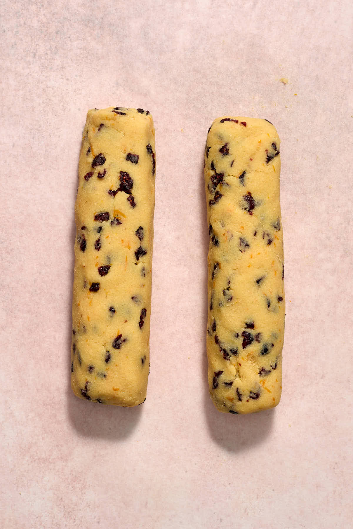 Cookie dough rolled into 2 logs on a sheet of parchment paper.