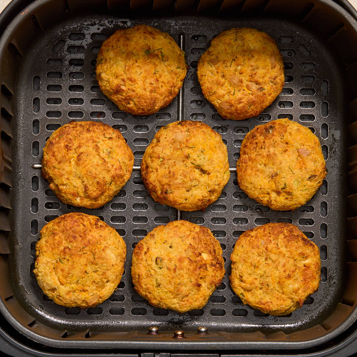 Tuna cakes cooked in the air fryer basket.