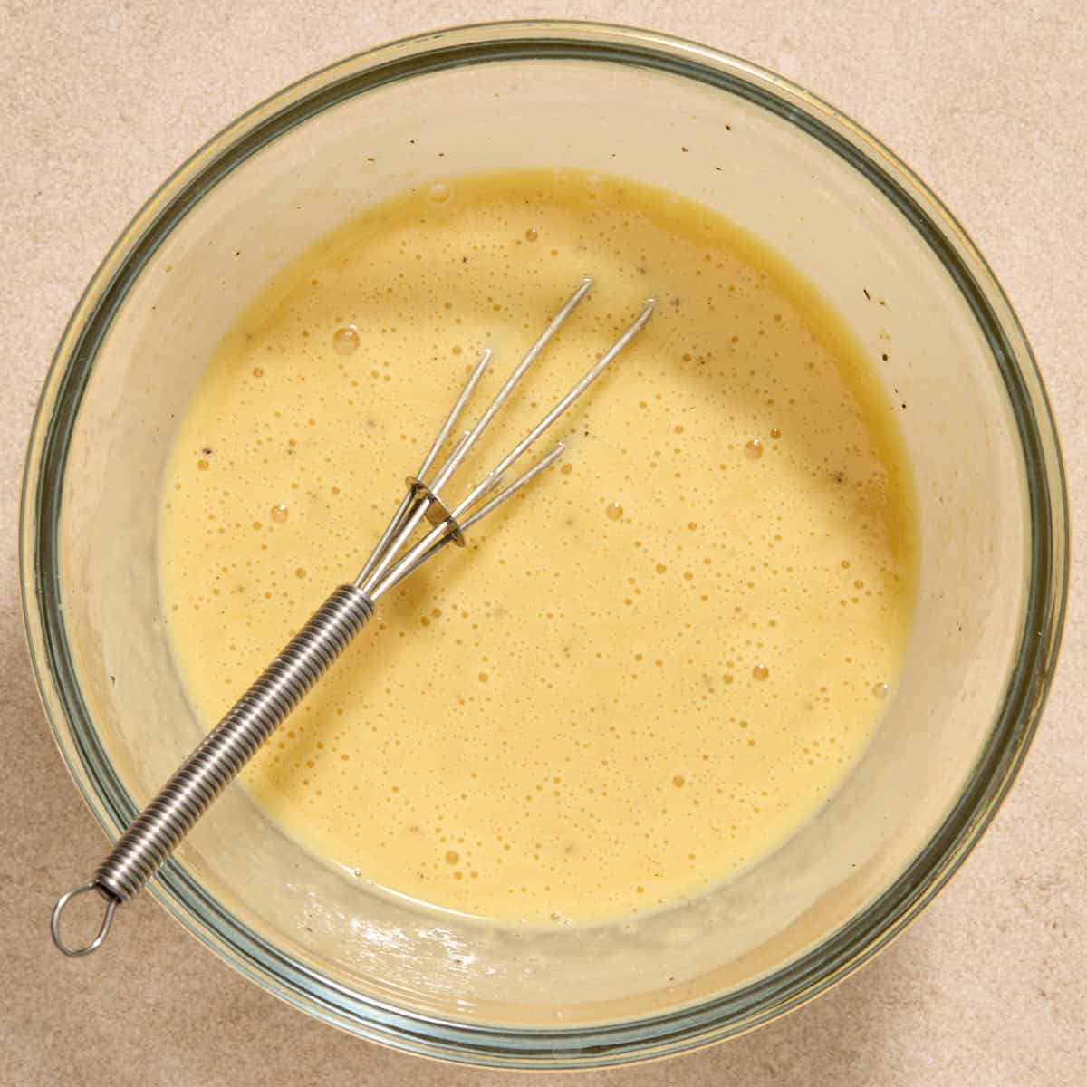 Egg, mayo, mustard, lemon juice and seasonings whisked together in a bowl.