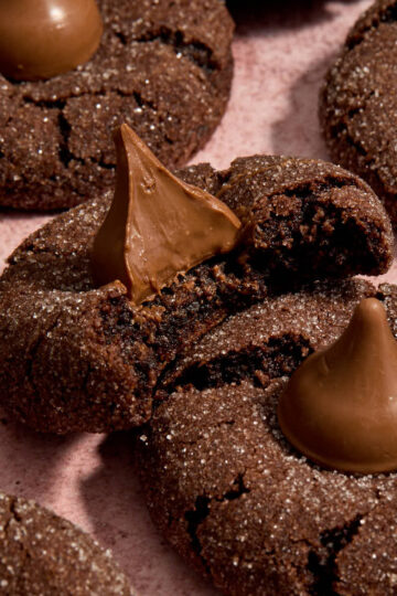 Angled view of cookies close together with a bite taken from one and resting on top of another.