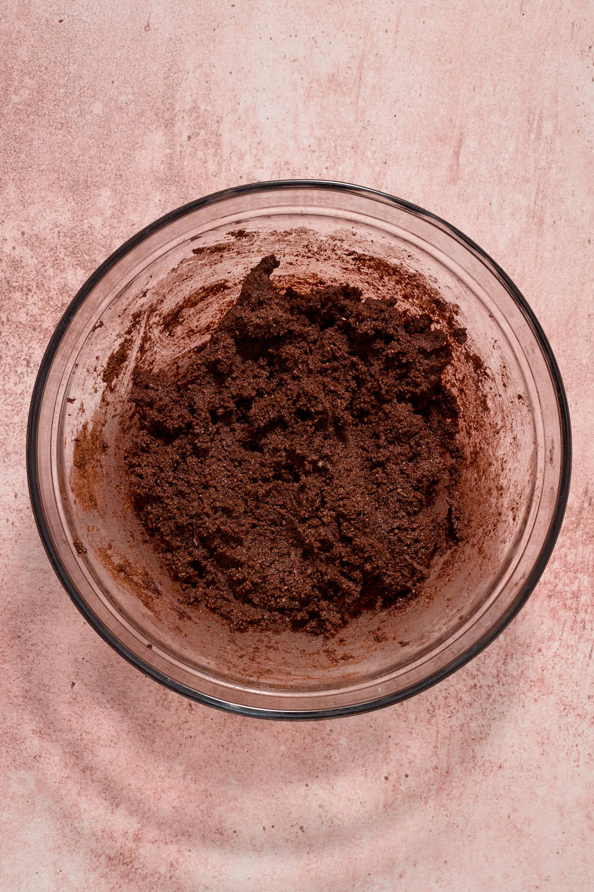 Chocolate cookie dough fully mixed together in a glass bowl.