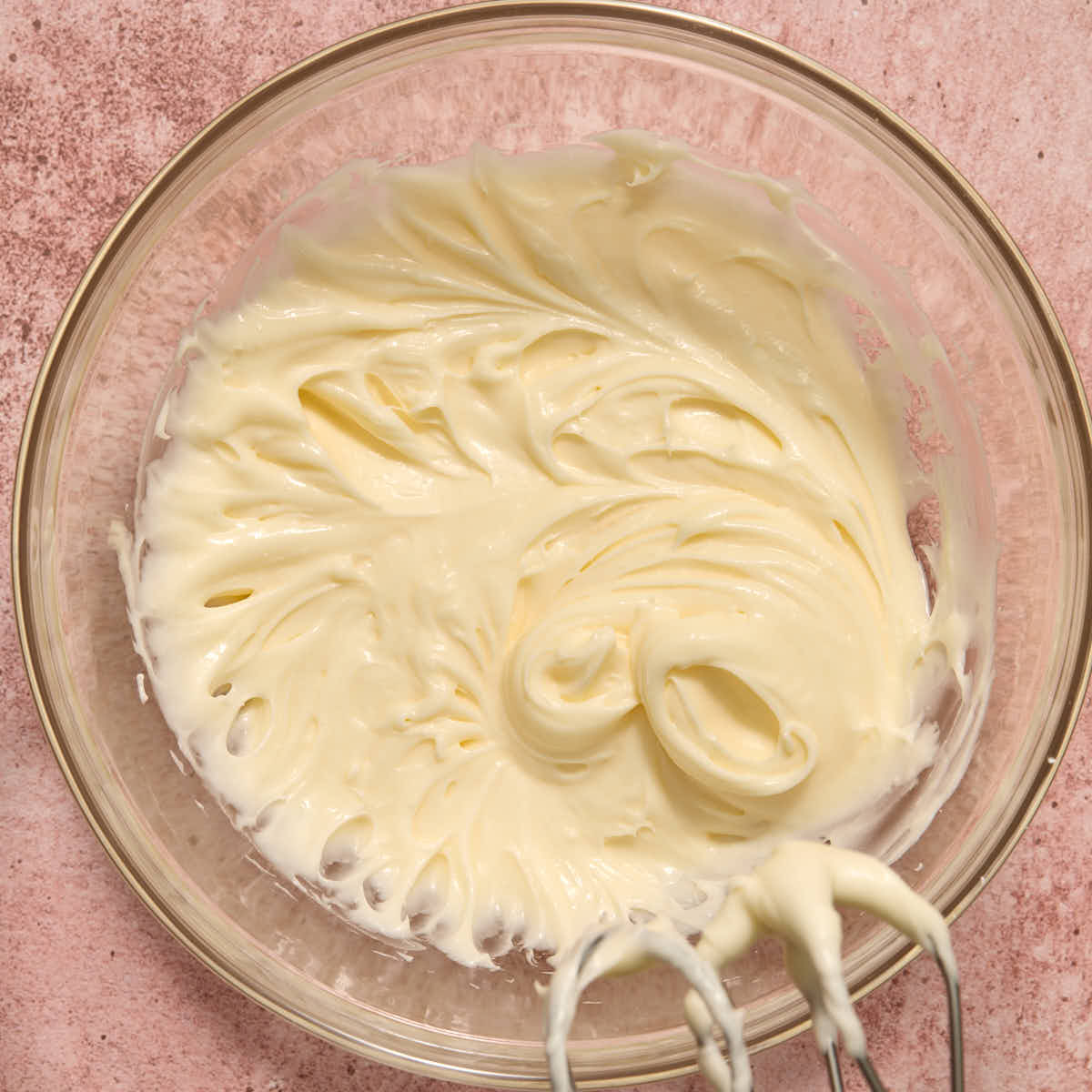 Cream cheese frosting whipped together in a glass bowl.