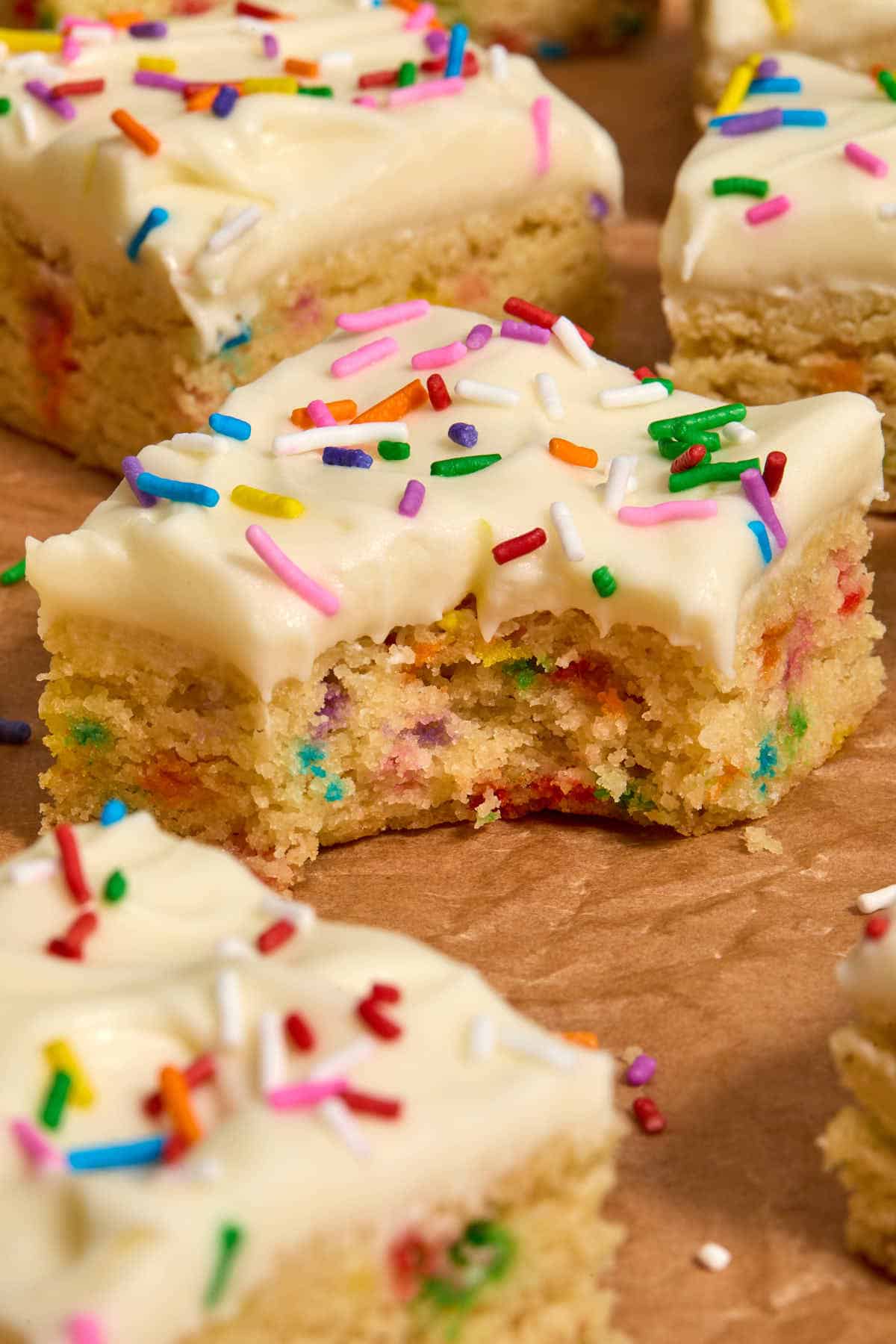 Side view of a sugar cookie bar with a bite taken out.