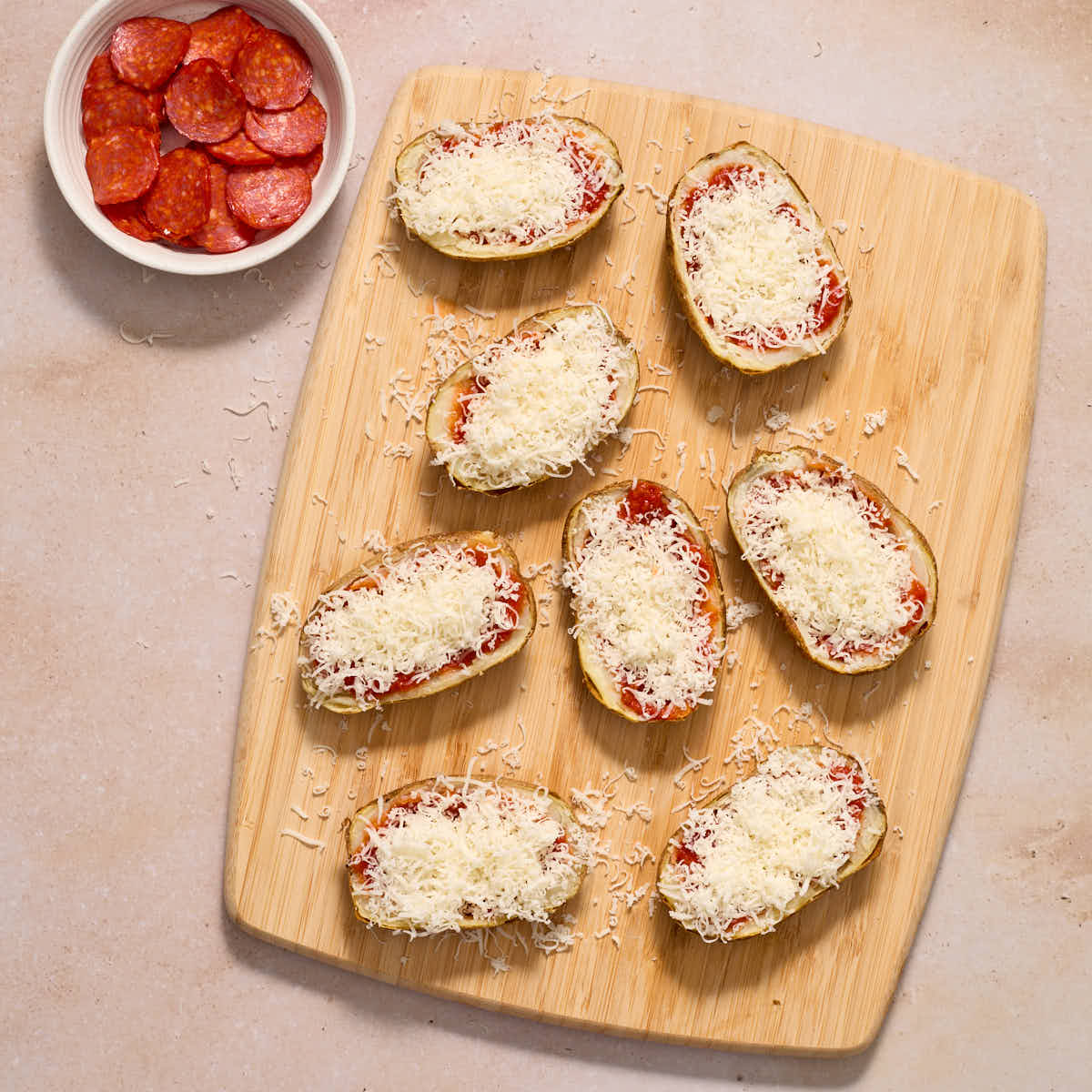 Grated mozzarella cheese added to each potato skin with pepperoni on the side.