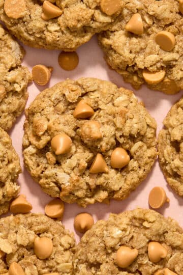 Close up overhead view of almond flour oatmeal butterscotch cookies on a pink surface.