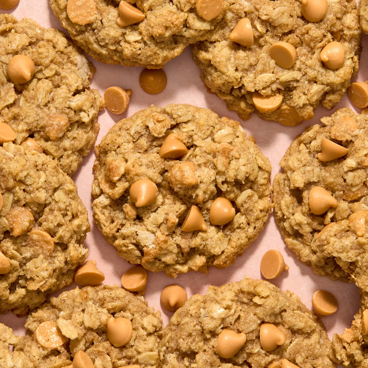 Close up overhead view of almond flour oatmeal butterscotch cookies on a pink surface.