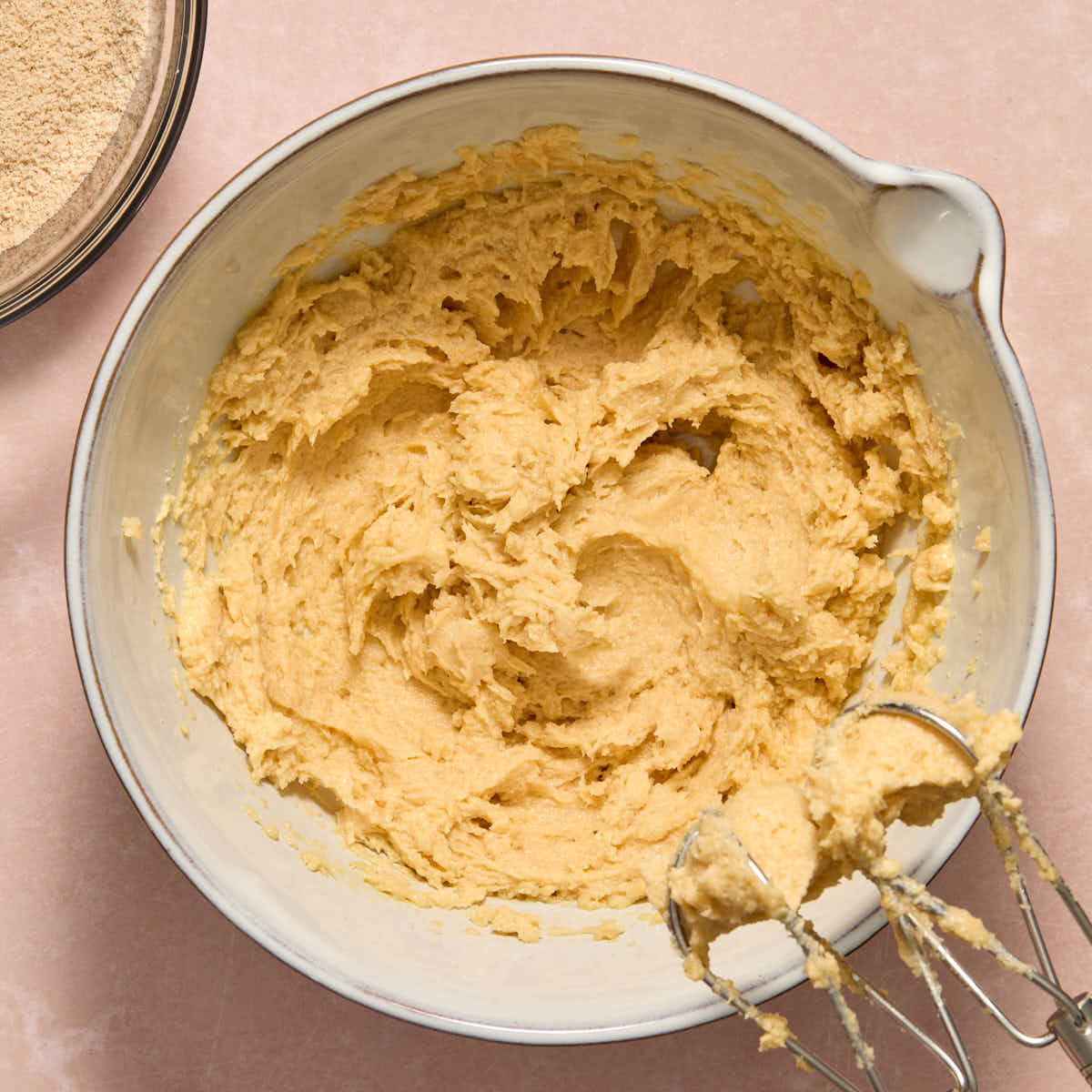 Eggs and vanilla mixed into the butter mixture in a white bowl.