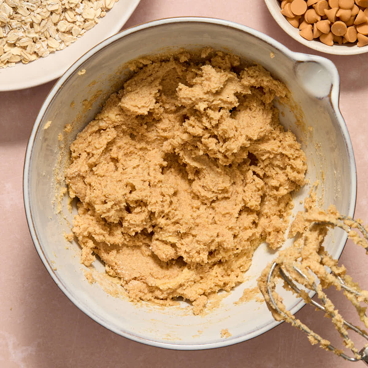 Dry ingredients mixed into the cookie dough with oats and butterscotch chips on the side.