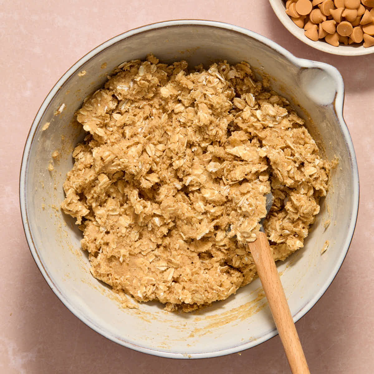 Oats mixed into the cookie dough in a white bowl.