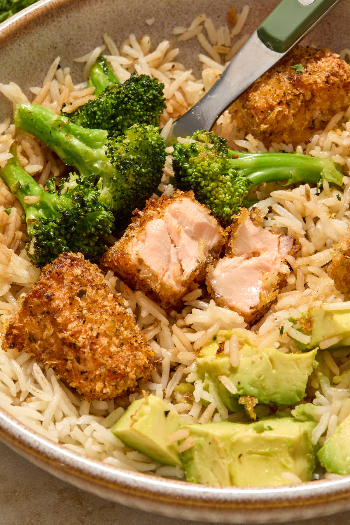 Close up of a salmon bite cut in half to show the flaky flesh.