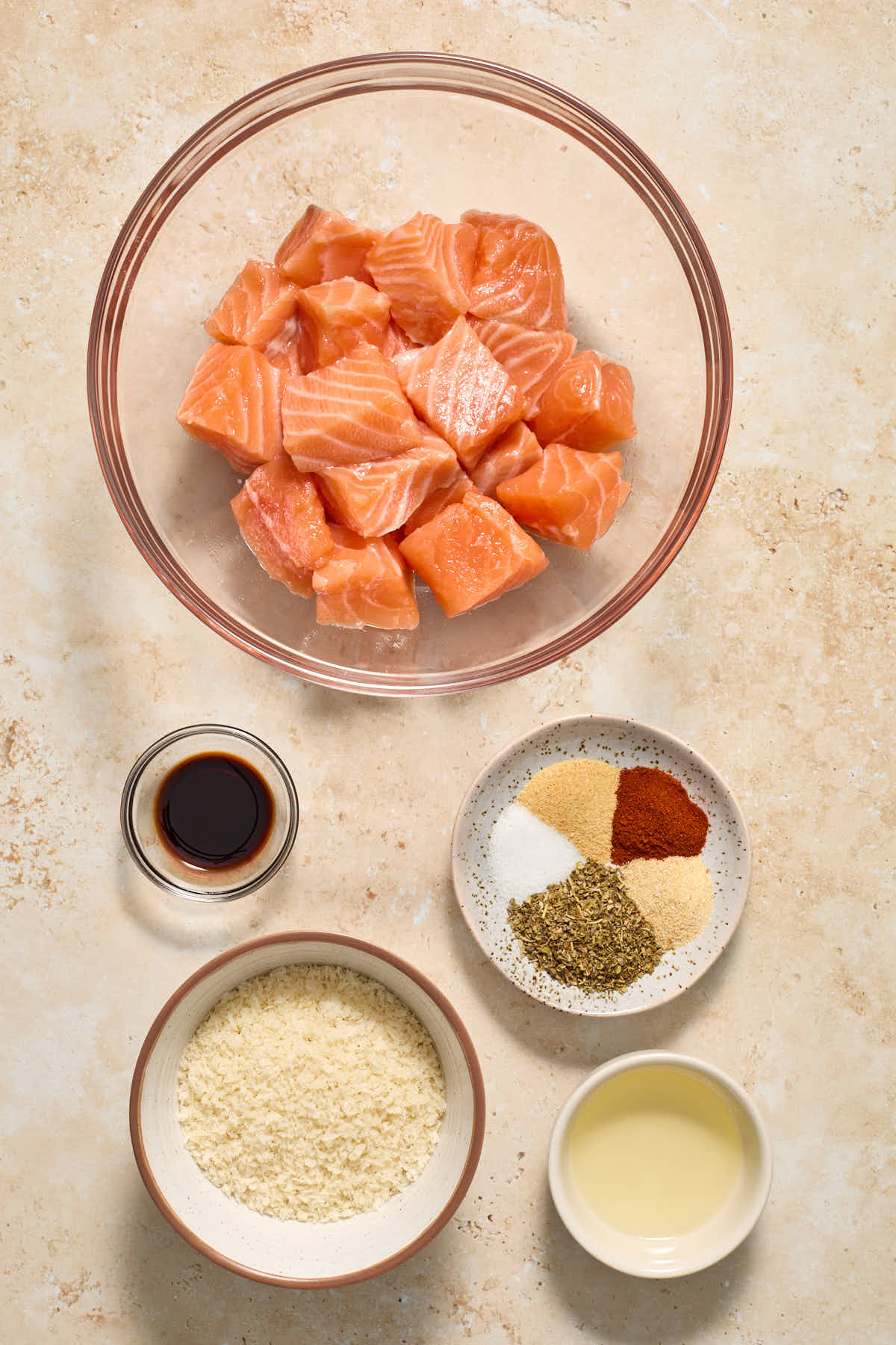 Ingredients to make air fryer breaded salmon bites arranged in individual bowls.