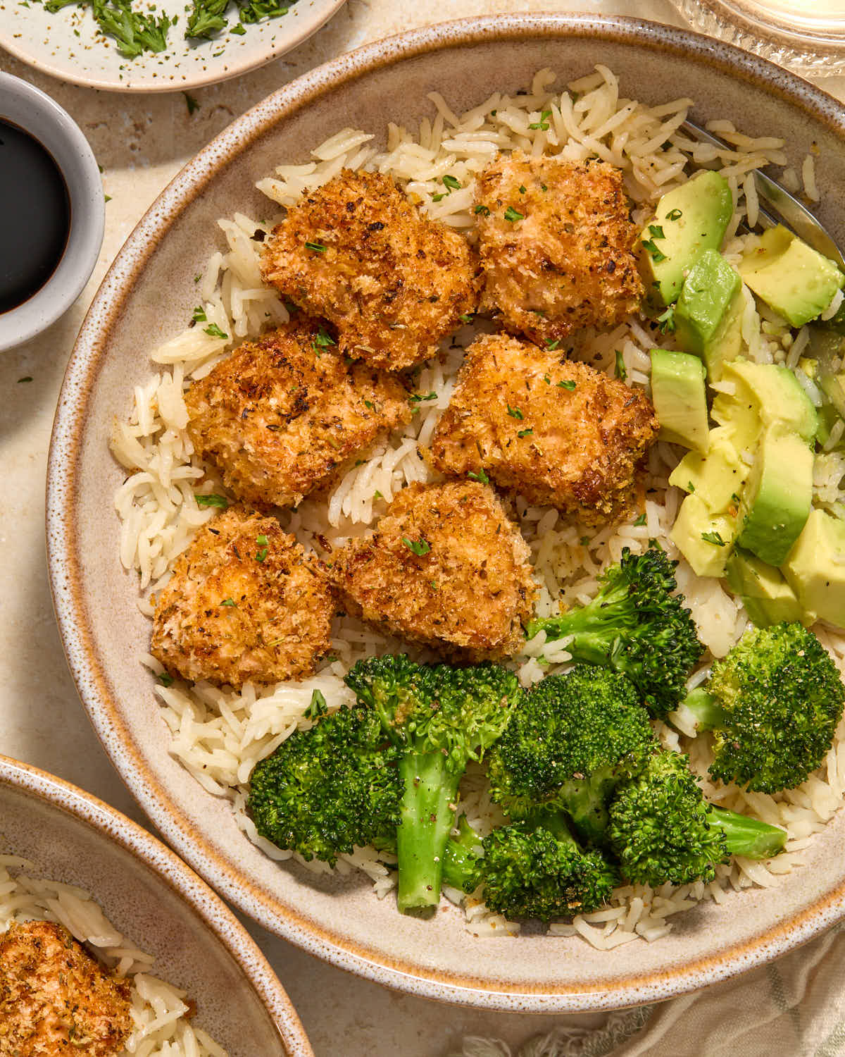 Overhead close up of salmon bites in a bowl on top of rice.