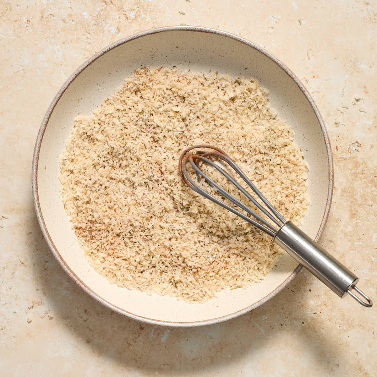 Panko crumbs and seasonings whisked together in a shallow bowl.