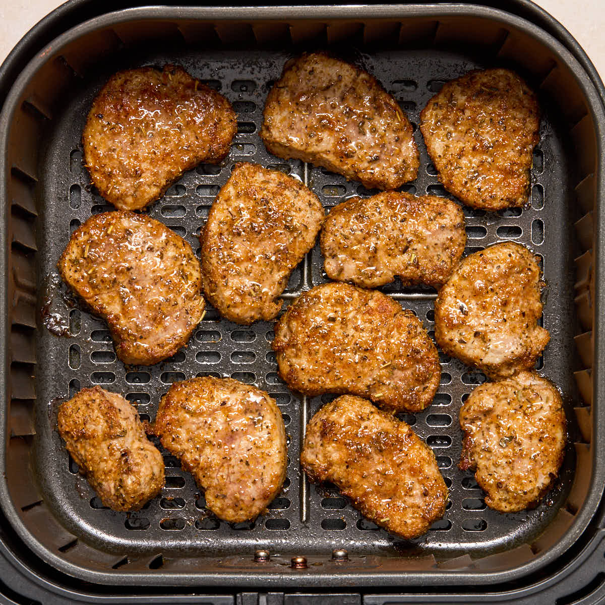 Air fried pork medallions in the air fryer basket.
