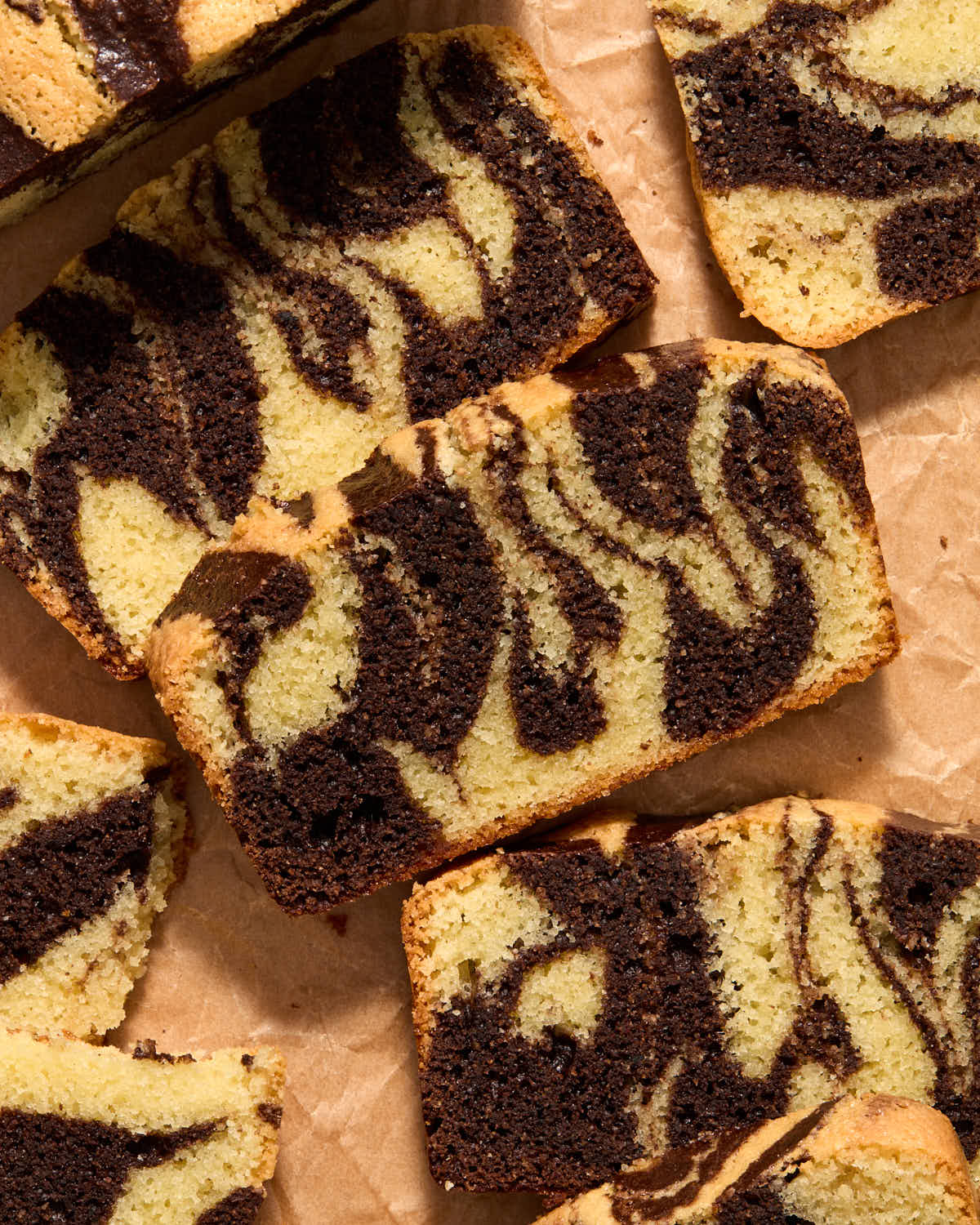 Overhead of slices of marble loaf arranged on parchment paper.