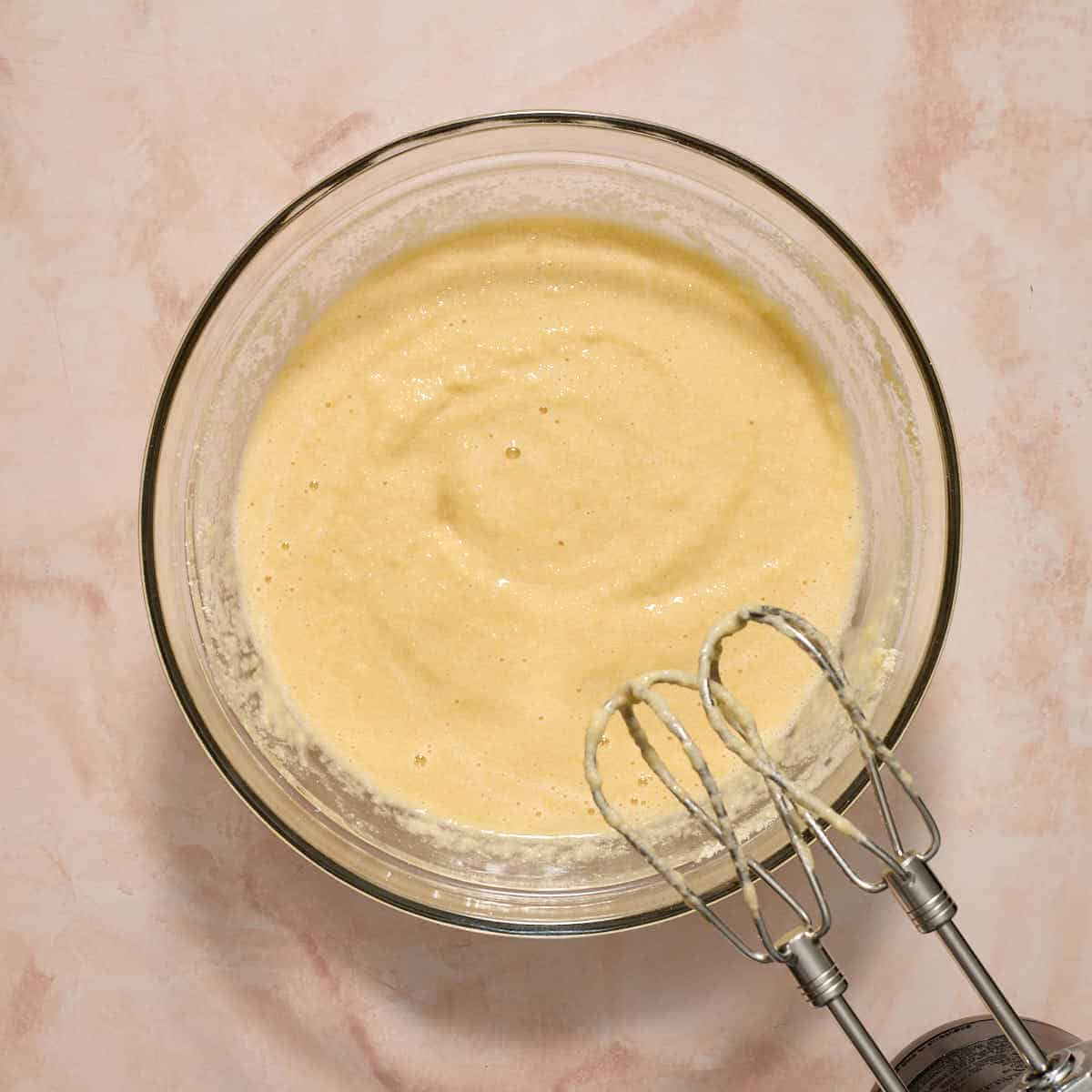 Dry ingredients mixed into the vanilla batter in a glass bowl.