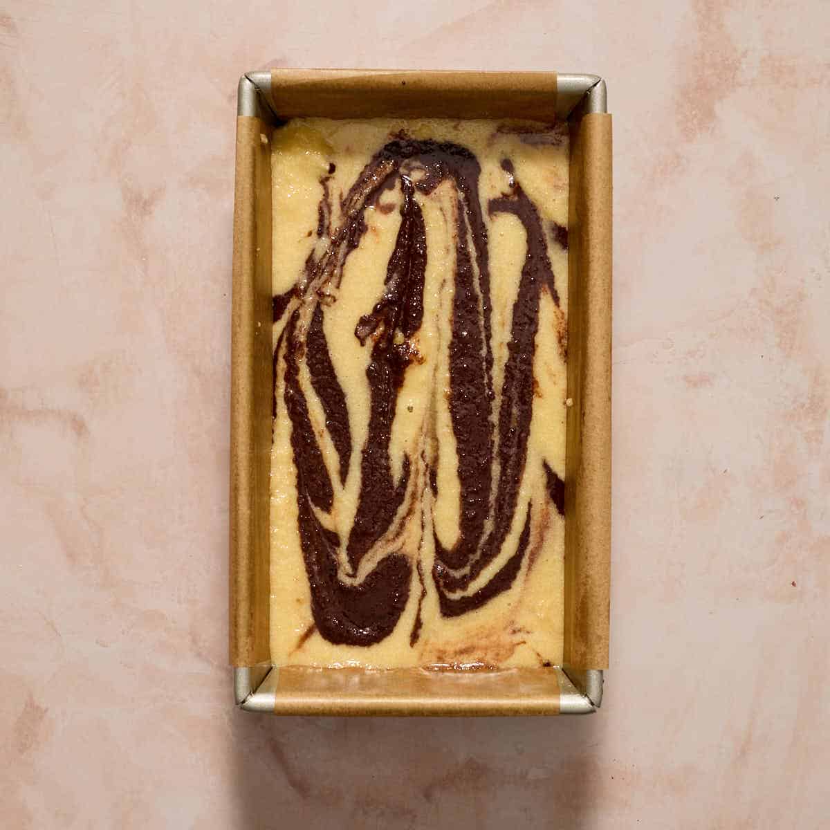 Cake batter swirled together in a loaf pan.