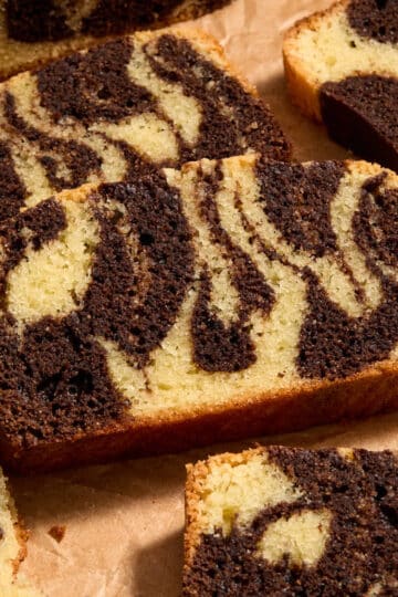 Close up of slices of almond flour chocolate marble loaf on brown parchment paper.