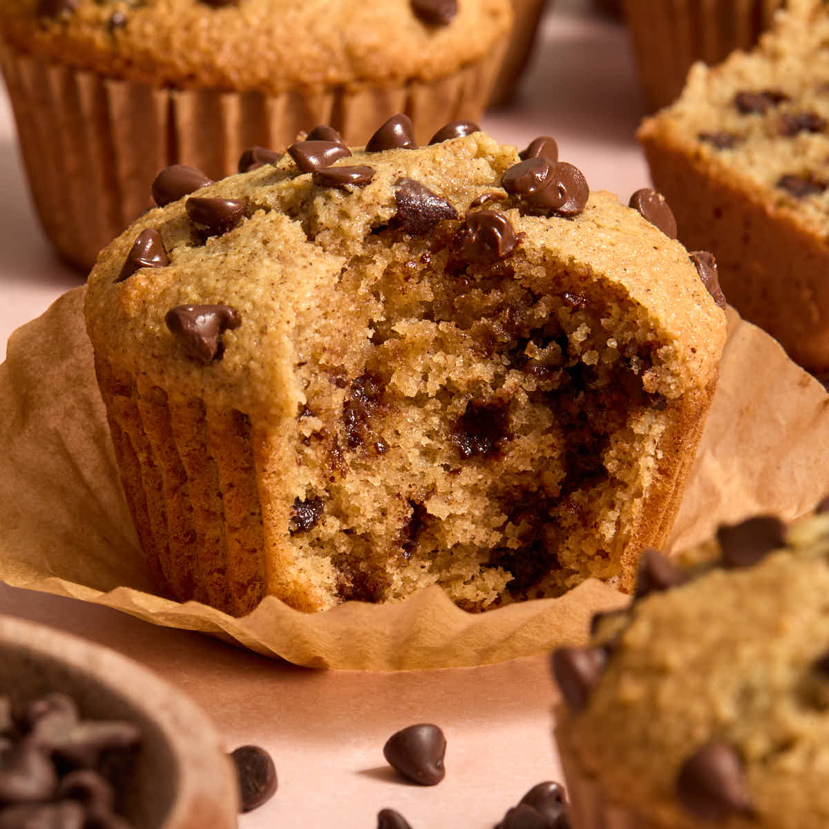 Side view of an almond flour cinnamon chocolate chip muffin with a bite taken.