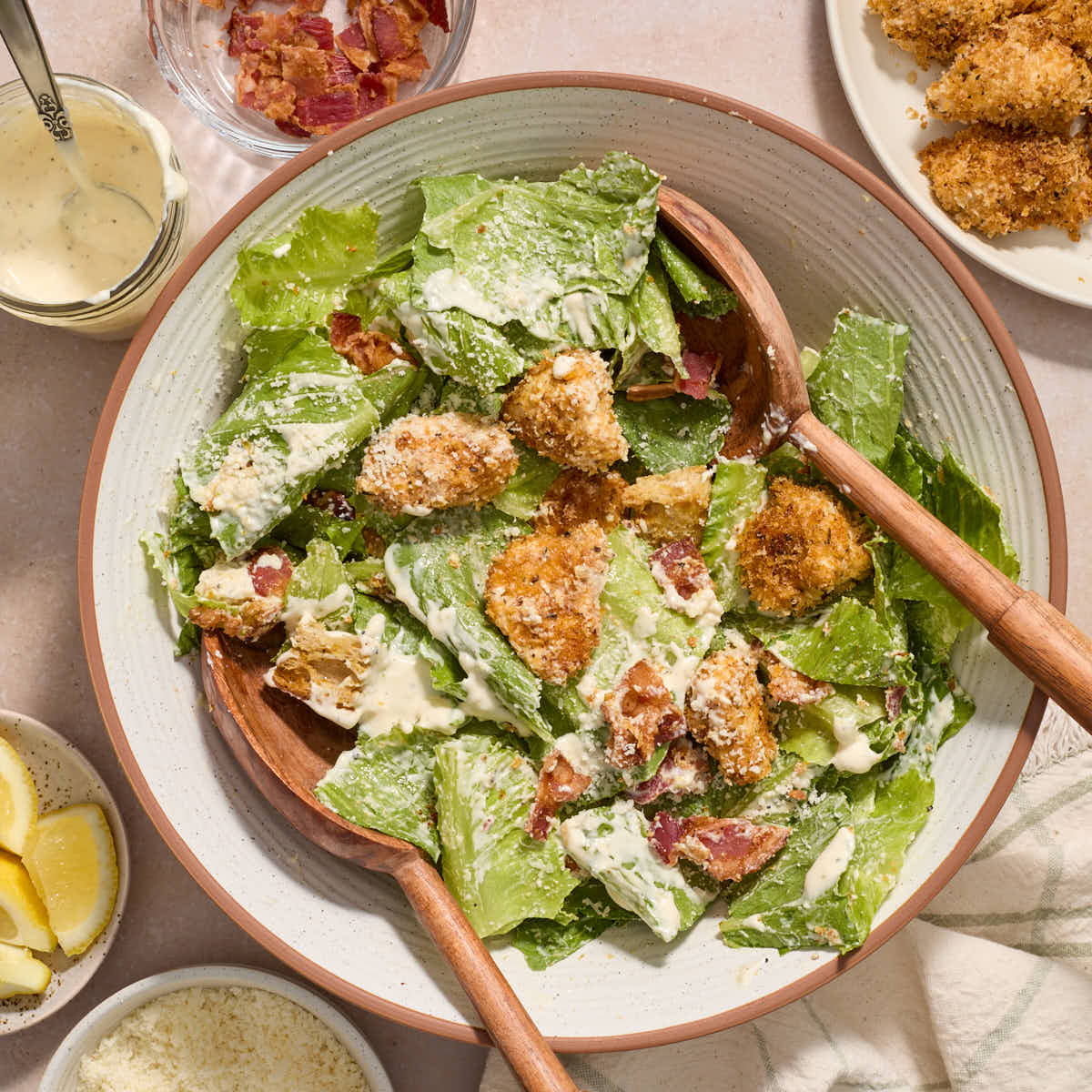 Salad ingredients tossed together with the dressing in a white bowl.