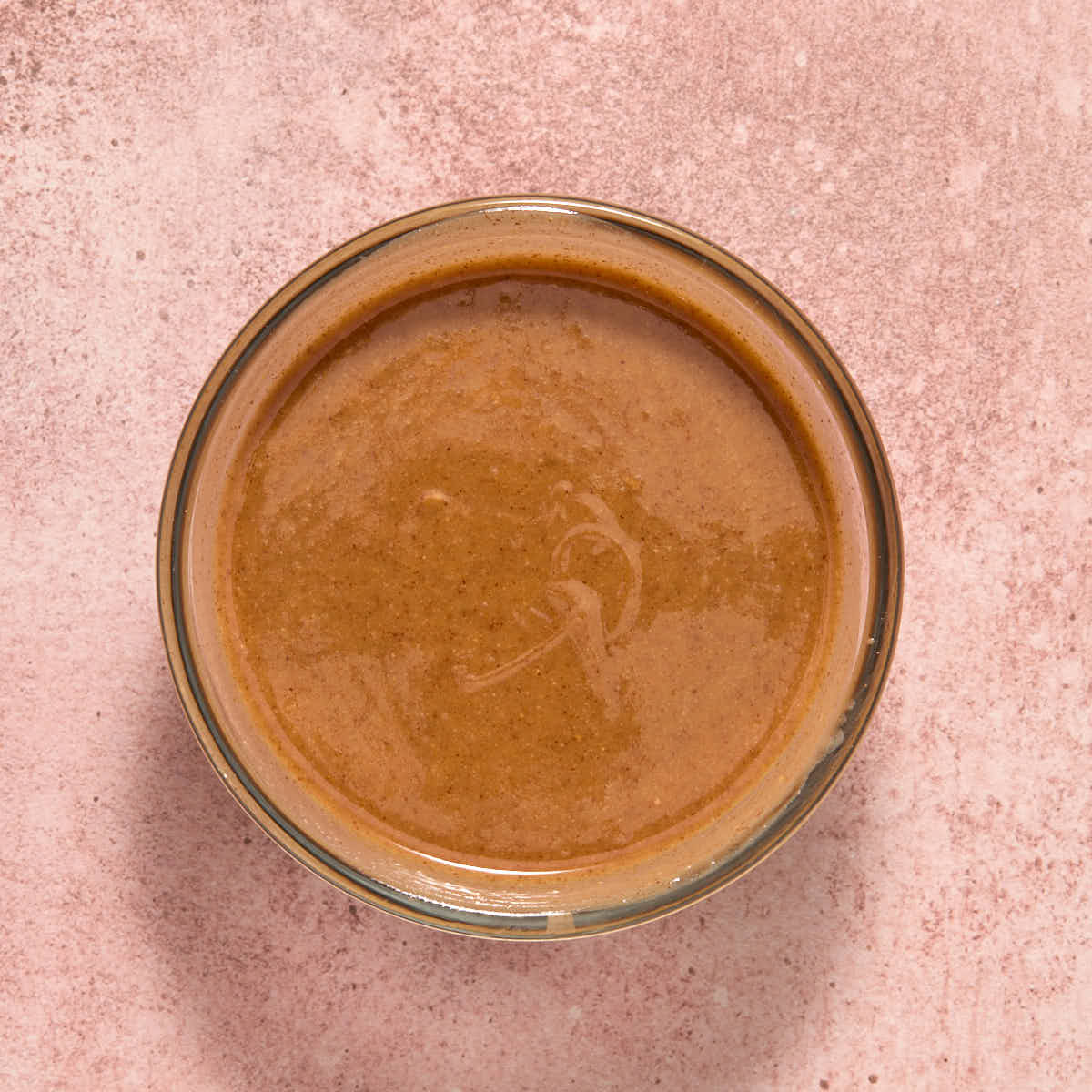 Melted almond butter mixture in a small glass bowl.