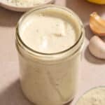 Caesar salad dressing in a glass jar.