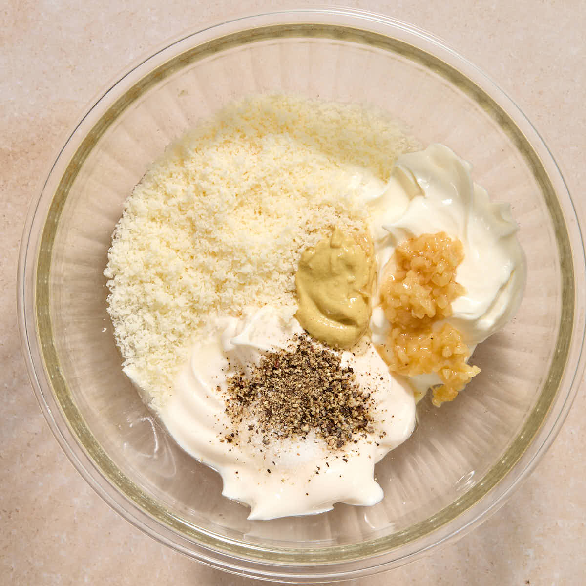 Dressing ingredients added to a glass bowl.