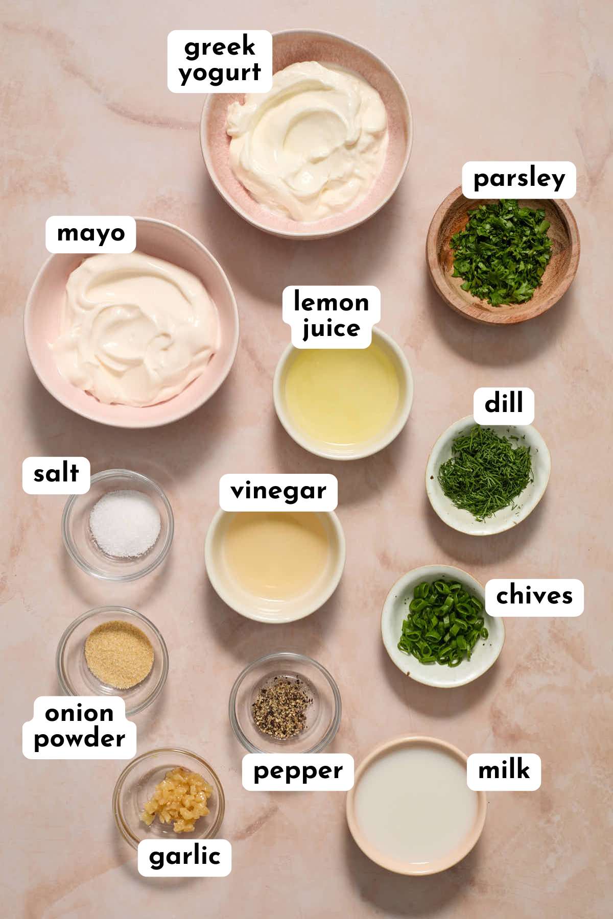 Ingredients to make ranch dressing arranged in individual bowls and labeled.