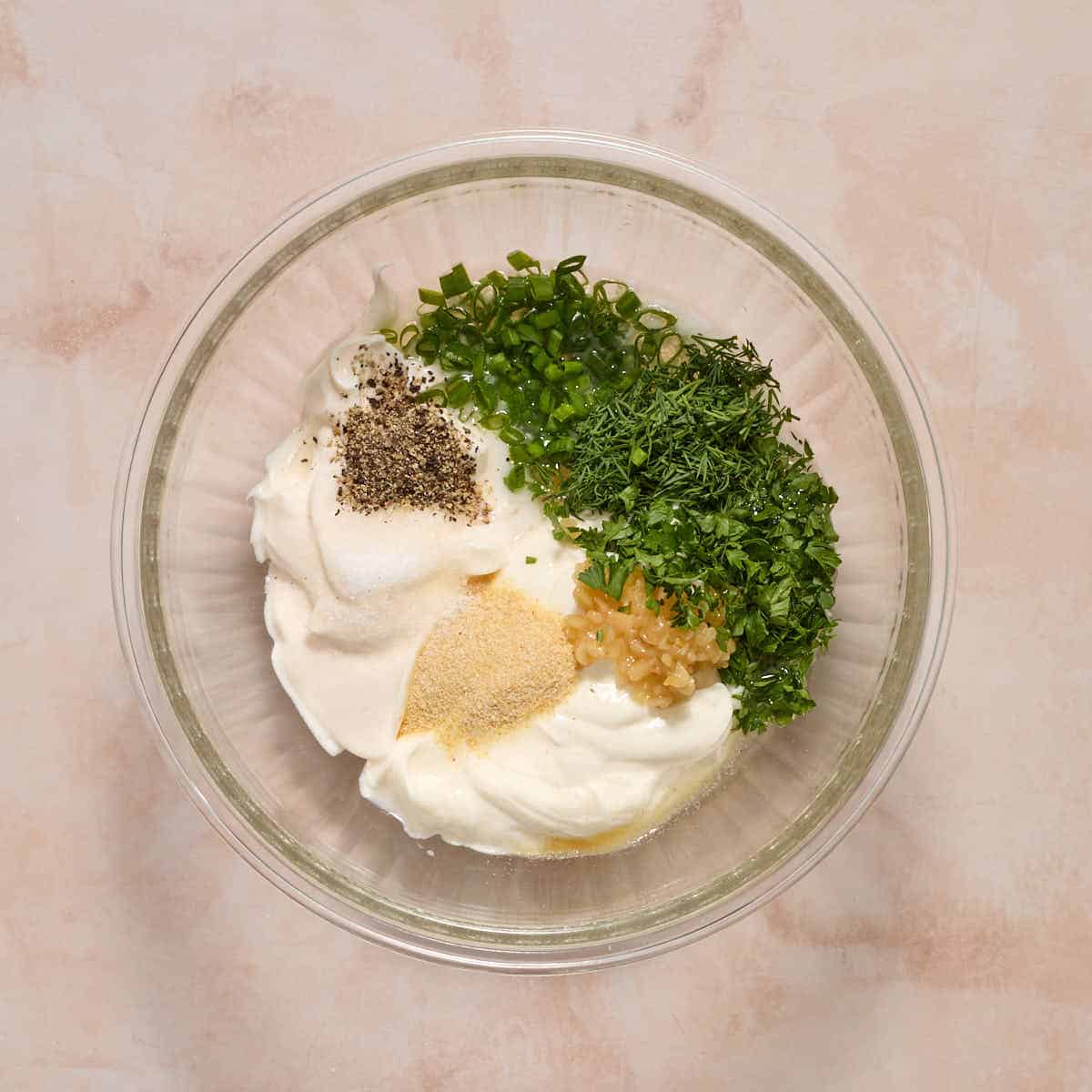 Ingredients to make ranch dressing added to a glass bowl.