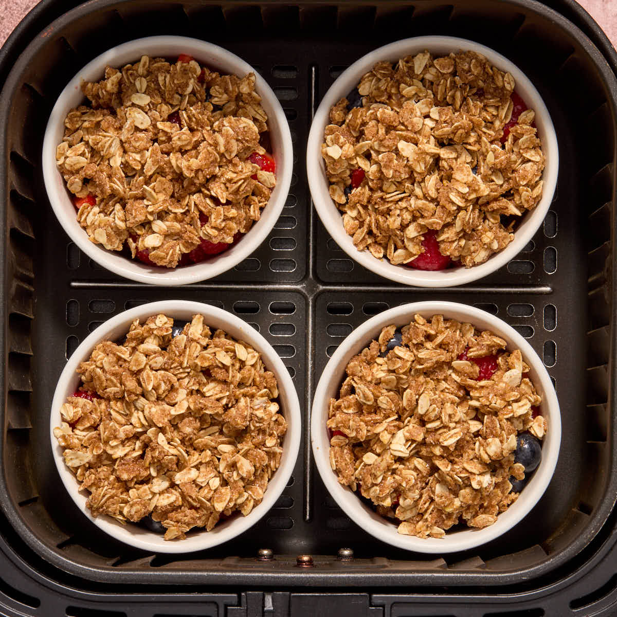 Ramekins placed in the air fryer basket.