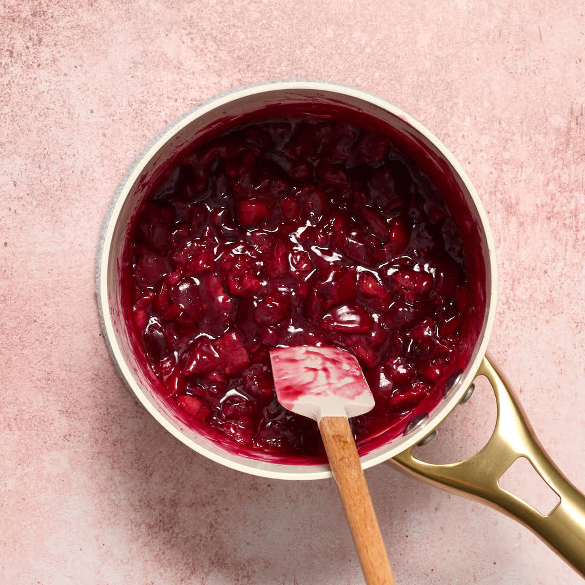 Cherry filling cooked in a small saucepan.